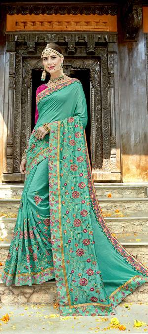 Beat The Heat This Summer With Bright Colors At the Next Function. Grab This Designer Saree In Sea Green Color Paired With Contrasting Rani Pink Colored Blouse. This Saree And Blouse Are Silk Based Beautified With Heavy Embroidery All Over. 
