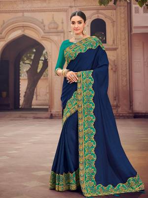 The fabulous pattern makes this Navy Blue color two tone satin silk saree. Ideal for party, festive & social gatherings. this gorgeous saree featuring a beautiful mix of designs. Its attractive color and designer heavy embroidered design, moti design work, patch design, beautiful floral design all over in saree work over the attire & contrast hemline adds to the look. Comes along with a contrast unstitched blouse.