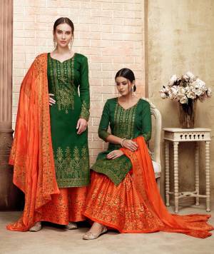 Here Is A Proper Traditional Color Pallete With This Designer Straight Suit In Dark Green Colored Top Paired With Contrasting Orange Colored Bottom And Dupatta. Its Top Is Fabricated On Art Silk Paired With Cotton Bottom And Chiffon Dupatta. It Is All Over Beautified With Prints and Stone Work.