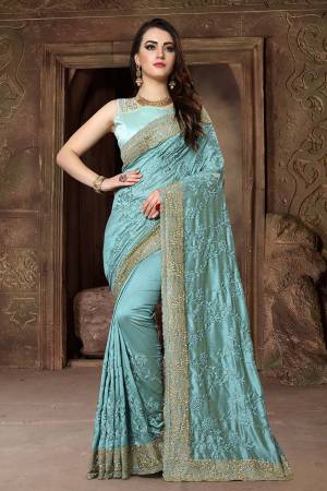 Get Ready For The Upcoming Festive And Wedding Season With This Heavy Designer Saree In Turquoise Blue Color Paired With Turquoise Blue Colored Blouse. This Saree Is Fabricated In Art Silk Paired With Satin Silk Fabricated Blouse. Its Heavy Embroidery And Rich Fabric Will Earn You Lots Of Compliments From Onlookers. 