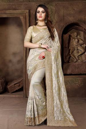 Get Ready For The Upcoming Festive And Wedding Season With This Heavy Designer Saree In Beige Color Paired With Beige Colored Blouse. This Saree Is Fabricated In Art Silk Paired With Satin Silk Fabricated Blouse. Its Heavy Embroidery And Rich Fabric Will Earn You Lots Of Compliments From Onlookers. 