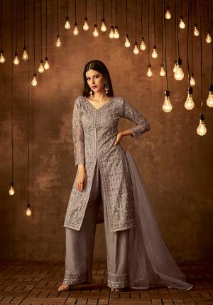 New Shade Is Here To Add Into Your Wardrobe With This Designer Suit In Mauve Grey Color Which Is Shade Of Light Purple And Grey. Its Top And Dupatta Are Net Fabricated Paired With Satin Raw Silk Fabricated Bottom. It Has Very Pretty Tone To Tone Embroidery Which Is Giving A Pretty Subtle Look.