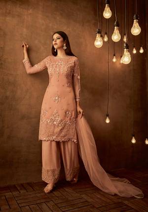 Here Is A Very Pretty Attractive Designer Straight Suit In Peach Color Paired With Peach Colored Bottom And Dupatta. Its Top Is Fabricated On Net Paired With Satin Raw Silk Bottom And Net Fabricated Dupatta. All Its Fabric Are Light Weight And Easy To Carry All Day Long. Buy Now.