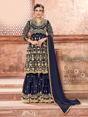 This Festive Season, Grab This Heavy Designer Sharara Suit In Navy Blue Color Paired With Navy Blue Colored Bottom And Dupatta. Its Heavy Embroidered Top And Bottom Are Fabricated On Satin Georgette Paired With Chinon Fabricated Dupatta. Buy This Semi-Stitched Suit Now.
