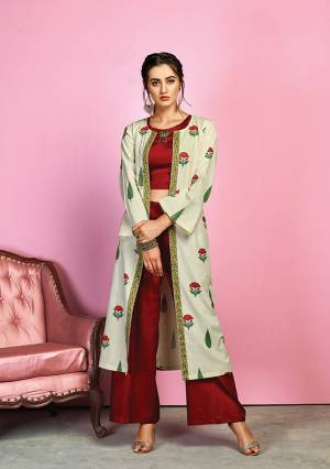 Grab This Designer Indo-Western Dress In Maroon Colored Top And Bottom Paired With Off-White Colored Jacket. Its Crop Top And Pants Are Fabricated On Cotton Satin Paired With Handloom Cotton Floral Printed Jacekt. I