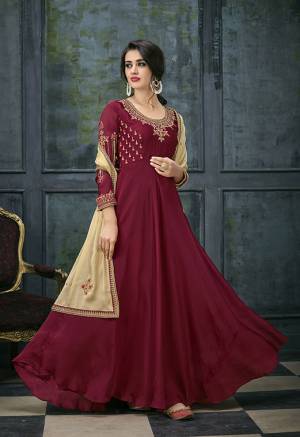 For A Royal Look, Grab This Deisgner Floor Length Suit In Maroon Color Paired With Beige Colored Dupatta. Its Pretty Embroidered Top Is Fabricated On Satin Georgette Paired With Santoon Bottom And Chiffon Dupatta. This Suit Is Light Weight And Easy To Carry All Day Long. 