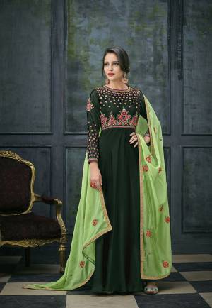 Go Green With This Designer Floor Length Suit In Dark Green Colored Top And Bottom Paired With Light Green Colored Dupatta. Its Top Is Satin Georgette Based Paired With Santoon Bottom And Chiffon Fabricated Dupatta. It Is Very Pretty Contrasting Embroidery Over The Yoke And Sleeves. 