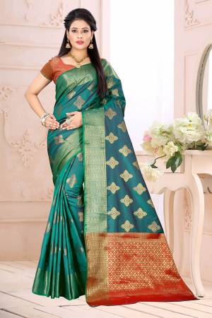 Celebrate This Festive Season Wearing This Saree In Blue Color Paired With Contrsating Orange Colored Blouse. This Saree Is Fabricated On Cotton Silk Paired With Jacquard Silk Fabricated Blouse. It Is Beautified With Weave All Over. 