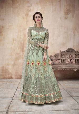 Here Is A Beautiful Designer Floor Length Suit In Light Green Color Paired With Light Green Colored Bottom And Dupatta. Its Heavy Embroidered Top IS Fabricated On Net Paired With Satin Silk Bottom And Net Fabricated Dupatta. This Pretty Suit Earn You Lots Of Compliments From Onlookers. 