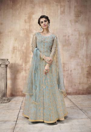 Summers Is About Subtle Shades And Pastel Play, So Grab This Designer Floor Length Suit In Light Blue Color Paired With Light Blue Colored Bottom And Dupatta. Its Heavy Embroidered Top Is Net Based Paired With Satin Silk Bottom And Net Fabricated Dupatta. Buy This Semi-Stitched Suit Now.