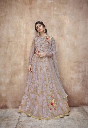 New Shade Is Here To Add Into Your Wardrobe. This Pretty Mauve Colored Designer Floor Length Suit Is A Shade Of Purple And Grey. It Is Paired With Mauve Colored Bottom And Dupatta. Its Heavy Embroidred Top And Dupatta Are Fabricated On Net Paired With Satin Silk Bottom. Buy This Rich Designer Suit Now.