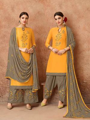 Celebrate This Festive Season With Ease, Comfort And Beauty By Getting This Dress Material Stitched As Per Your Desired Fit And Comfort. Its Top Is In Musturd Yellow Color Paired With Contrasting Grey Colored Bottom And Dupatta. This Dress Material Is Fabricated On Cotton Paired With Chiffon Dupatta. 