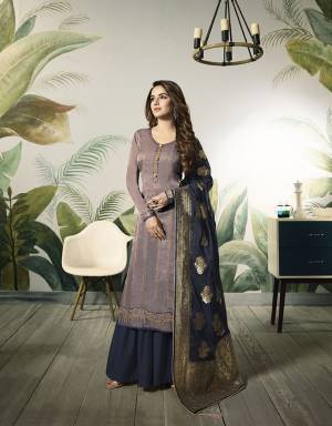 New Color Pallete Is Here To Add Into Your Wardrobe With This Designer Semi-Stitched Suit In Mauve Colored Top Paired With Contrasting Navy Blue Colored Bottom And Dupatta, Its Embroidered Top Is Fabricated On Satin Silk Paired With Santoon Bottom And Banarasi Silk Dupatta. 