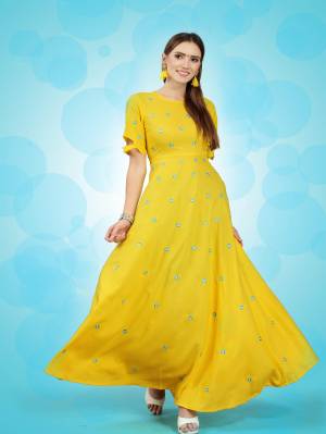You Will Definitely Earn Lots Of Compliments Wearing This Bright Yellow Colored Long Kurti. This Pretty Kurti Is Fabricated On Rayon Beautified With Thread Work Butti All Over It. 
