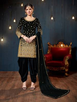 Get Ready For The Upcoming Festive And Wedding Season With This Heavy Designer Suit In Black Color. Its Heavy Embroidered Top Is Fabricated On Tafeta Art Silk Paired With Santoon Bottom And Net Fabricated Dupatta. It Is Beautified With Heavy Jari Embroidery And Mirror Work. 