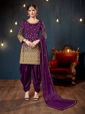 Get Ready For The Upcoming Festive And Wedding Season With This Heavy Designer Suit In Purple Color. Its Heavy Embroidered Top Is Fabricated On Tafeta Art Silk Paired With Santoon Bottom And Net Fabricated Dupatta. It Is Beautified With Heavy Jari Embroidery And Mirror Work. 