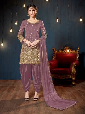 Get Ready For The Upcoming Festive And Wedding Season With This Heavy Designer Suit In Mauve Color. Its Heavy Embroidered Top Is Fabricated On Tafeta Art Silk Paired With Santoon Bottom And Net Fabricated Dupatta. It Is Beautified With Heavy Jari Embroidery And Mirror Work. 