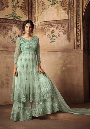 Very Pretty Shade Is Here With This Heavy Designer Sharara Suit In Aqua Blue. Its Top Bottom And Dupatta Are Fabricated On Net Beautified With Tone To Tone Embroidery Work Giving It A Subtle And Designer Look. 