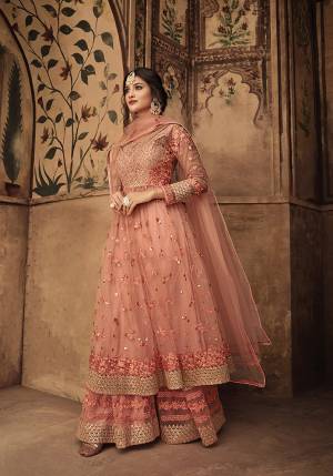 Look Beautiful In This Designer Sharara Suit In Very Pretty Peach Color. This Pretty Suit Is Net Fabricated Beautified With Attractive Tone To Tone Work .