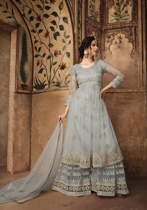 Flaunt Your Rich And Elegant Taste Wearing This Heavy Designer Sharara Suit In Grey Color Paired With Grey Colored Bottom And Dupatta. This Lovely Suit Is Fabricated On Net Beautified With Attractive Embroidery Over The Top and Bottom. Buy Now.