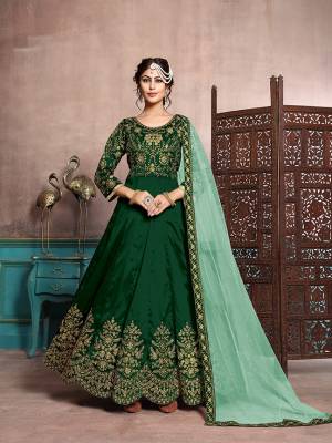 Here Is A Beautiful Designer Floor Length Suit In Dark Green Color Paired With Dark Green Colored Bottom And Light Green Colored Dupatta. Its Heavy Embroidered Top Is Fabricated On Art Silk Paired With Santoon Bottom And Net Fabricated Dupatta. Its Has Attractive Embroidery Over The Yoke, Panel And Dupatta Lace Border. 