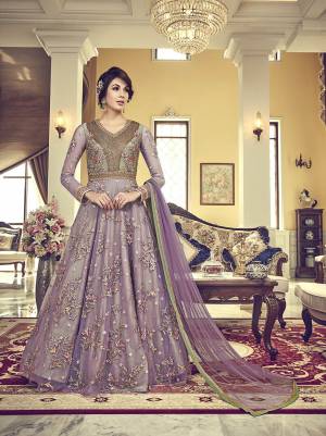 Here Is a Beautiful Shade In Purple With This Designer Floor Length Suit In Lavendor Color. Its Heavy Embroidered Top Is Fabricated On Net Paired with Santoon Bottom And Net Fabricated Dupatta. 
