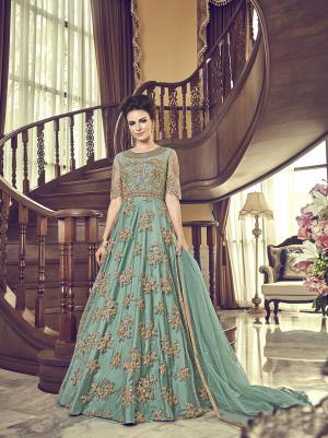 Grab This Beautiful Heavy Designer Floor Length Suit In Turquoise Blue Color. Its Heavy Embroidered Top IS Fabricated On Net Paired With Santoon Bottom And Net Fabricated Dupatta. Buy This Semi-Stitched Suit.