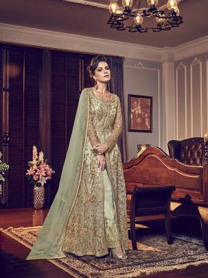 This season Is About Subtle Shades And Pastel Play So Grab This Designer Indo-Western Suit In Pastel Green. Its Heavy Embroidered Top IS Net Based Paired With Satin Fabricated Embroidered Bottom And Net Dupatta. 