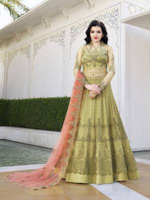 Here Is A Beautiful Heavy Designer Floor Length Suit In Pear Green Color Paired With Contrasting Peach Colored Dupatta. Its Top And Dupatta Are Fabricated On Net Paired With Satin Fabricated Embroidered Bottom.Buy This Semi-Stitched Suit Now.