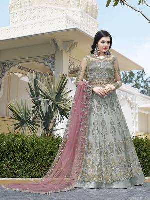 Flaunt Your Rich And Elegant Taste Wearing This Designer Heavy Floor Length Suit In Grey Color Paired With Contrasting Dusty Pink Colored Dupatta. Its Heavy Embroidered Top Is Fabricated On Net Paired With Satin Bottom and Net Fabricated Dupatta.