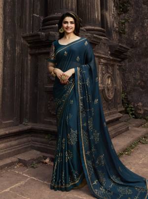 Add This Beautiful Shade To Your Wardrobe With This Designer Teal Blue Colored Saree And Blouse. This Saree Is Georgette Based Paired With Silk Based Blouse. It Has Foil Prints Over Saree Giving It An Attractive Look. 