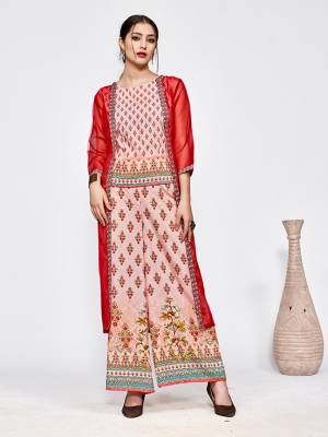 Here Is A Very Pretty Designer Indo-Western Three Piece Set. Its Top And Bottom Are In Baby Pink Color Paired With Red Colored Jacket. It Is Fabricated On Muslin Beautified With Prints All Over Paired With Orgenza Fabricated Jacket. Buy Now.
