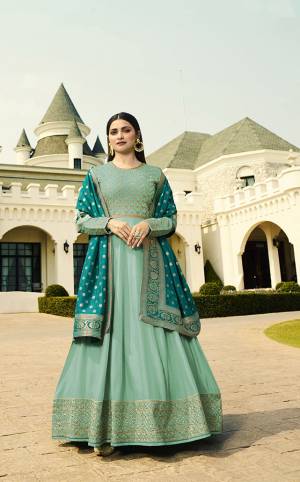 Go With The Shades Of Blue With This Designer Floor Length Suit In Turquoise Blue Color Paired With Blue Colored Dupatta. Its Pretty Embroidered Top Is Fabricated On Soft Art Silk Paired With Santoon Bottom And Banarasi Art Silk Dupatta.