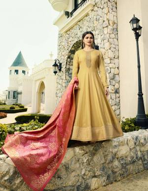Celebrate This Festive Season Wearing This Attractive Designer Floor Length Suit In Yellow Color Paired With Contrasting Pink Colored Dupatta, Its Embroidered Top Is Fabricated On Soft Art Silk Paired With Santoon Bottom And Banarasi Art Silk Dupatta. 