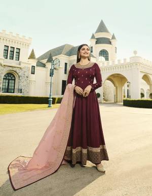 Celebrate This Festive Season Wearing This Attractive Designer Floor Length Suit In Maroon Color Paired With Contrasting Baby Pink Colored Dupatta, Its Embroidered Top Is Fabricated On Soft Art Silk Paired With Santoon Bottom And Embroidered Georgette Fabricated Dupatta. 