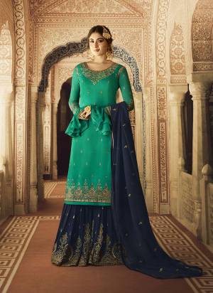 Grab This Beautiful Designer Sharara Suit In Sea Green Colored Top Paired With Contrasting Navy Blue Colored Bottom And Dupatta. Its Top Is Fabricated On Satin Georgette Paired With Georgette Bottom And Dupatta. All Three Piece Are Beautified With Attractive Embroidery. 