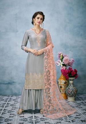 Flaunt Your Rich And Elegant Taste Wearing This Designer Suit In Grey Color Paired With Contrasting Peach Colored Dupatta. Its Embroidered Top Is Fabricated On Banarasi Jacquard Silk Paired With Santoon Bottom And Heavy Lakhnavi Embroidered Net Fabricated Dupatta. 