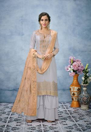 Simple And Elegant Looking Designer Suit Is Here In Grey Color Paired With Contrasting Orange Colored Dupatta. Its Top Is Fabricated On Banarasi Jacquard Silk Paired With Santoon Bottom And Net Fabricated Heavy Lakhnavi Dupatta. 
