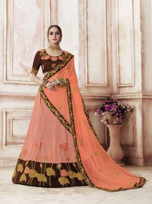 This Wedding Season Look The Most Amazing Of All Wearing This Designer Lehenga Choli In Brown Colored Blouse Paired With Contrasting Dark Peach Colored Lehenga And Dupatta. This Rich Silk Based Lehenga Choli Is paired With Net Fabricated Dupatta.  