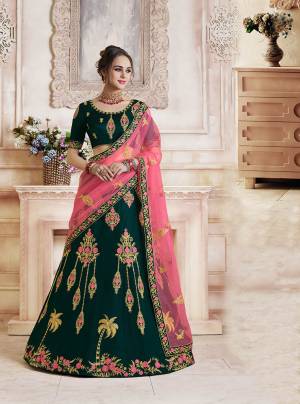 Catch All The Limelight Wearing This Heavy Designer Lehenga Choli In Dark Teal Green Colo Paired With Contrasting Pink Colored Dupatta. Its Blouse And Lehenga Are Silk Based Paired With Net Fabricated Dupatta. Its Rich Fabric And Color Pallete Will Earn You Lots Of Compliments From Onlookers. 
