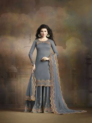 Flaunt Your Rich And Elegant Taste Wearing This Heavy Designer Suit With Embroidered Top, Bottom And Dupatta All In Dark Grey Color. Its Top And Bottom Are Fabricated On Soft Silk Paired With Net Fabricated Dupatta. 