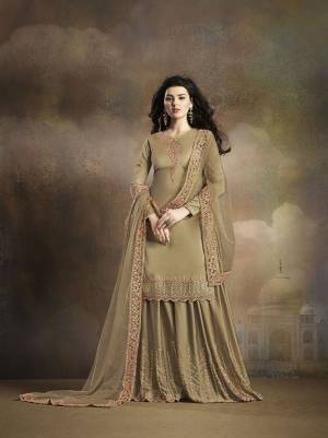 Flaunt Your Rich And Elegant Taste Wearing This Heavy Designer Suit With Embroidered Top, Bottom And Dupatta All In Beige Color. Its Top And Bottom Are Fabricated On Soft Silk Paired With Net Fabricated Dupatta. 