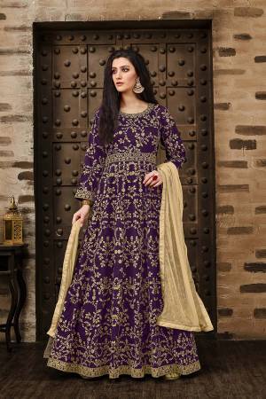 Here Is A Beautiful Heavy Designer Floor Length Suit In Purple Color Paired With Beige Colored Dupatta. Its Heavy Embroidered Floor Length Top Is Fabricated On Tafeta Silk Paired With Santoon Bottom And Net Fabricated Dupatta. Buy Now.