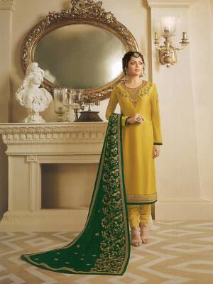 Celebrate This Festive Season Wearing This Heavy Designer Straight Suit In Yellow Colored Top And Bottom Paired With Contrasting Dark Green Colored Dupatta. Its Top Is Fabricated On Satin Georgette Paired With Santoon Bottom And Georgette Fabricated Heavy Embroidered Dupatta. 
