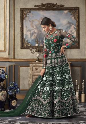 Shine Bright Wearing This Heavy Designer Floor Length Suit In Dark Green Color Paired With Dark Green Colored Bottom And Dupatta. Its Top And Dupatta Are Net Fabricated Paired With Art Silk Bottom And Inner. Its top Is Beautified With Heavy Contrasting Work All Over. 