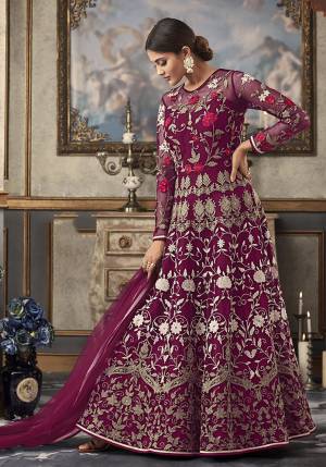 Shine Bright Wearing This Heavy Designer Floor Length Suit In Magenta Pink Color Paired With Magenta Pink Colored Bottom And Dupatta. Its Top And Dupatta Are Net Fabricated Paired With Art Silk Bottom And Inner. Its top Is Beautified With Heavy Contrasting Work All Over. 