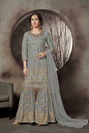 This Summer Is About Subtle Shades And Pastel Play, Grab This Heavy Designer Sharara Suit In Grey Color. This Pretty Suit Is Net Based. Its Top And Bottom Are Beautified With Heavy Tone To Tone Embroidery Which Gives A Heavy Rich And Subtle Look To Your Personality. Buy Now.