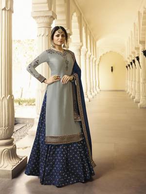 Flaunt Your Rich And Elegant Taste Wearing This Heavy Designer Indo-Western Suit In Grey Colored Top Paired With Navy Blue Colored Bottom And Dupatta. Its Top Is Fabricated On Satin Georgette Paired With Brocade Fabricated Bottom And Chiffon Dupatta With Lace Border. 
