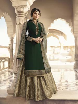 Here Is Royal Color Pallete Of Queen With This Designer Indo-Western Suit In Dark Green Colored Top Paired With Beige Colored Bottom And Dupatta. Its Top Is Fabricated On Satin Georgette Paired With Brocade Bottom And Net Fabricated Dupatta. All Its Fabrics are Light Weight And Easy To Carry All Day Long. 