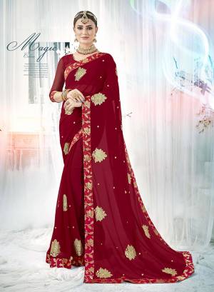 For A Royal And Attractive Look, Grab This Designer Saree In Maroon Color Paired With Maroon Colored Blouse. This Saree And Blouse Are Fabricated On Georgette Beautified With Attractive Butti Work all Over The Saree. Buy Now.